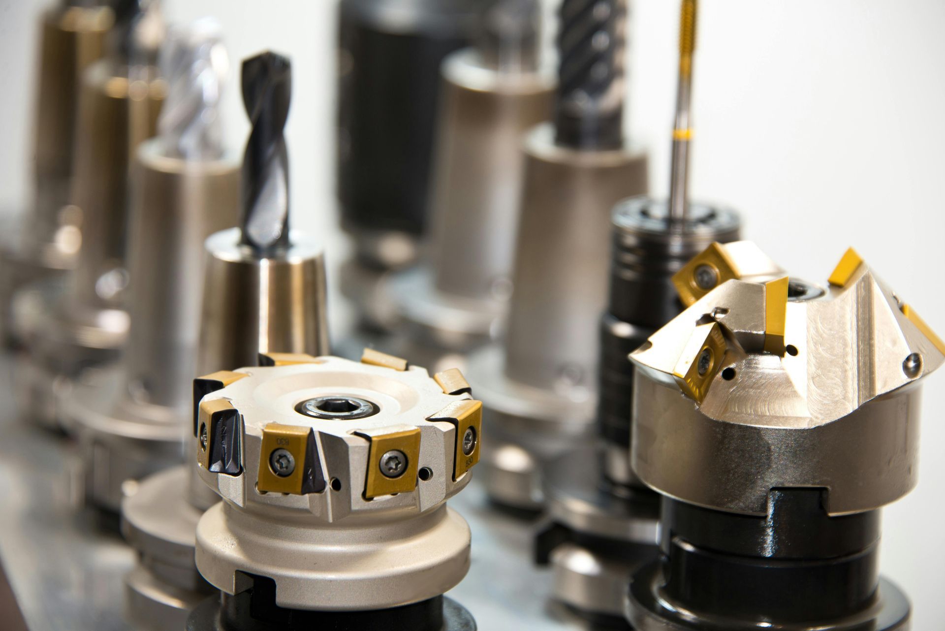 Metal machine tool bits lined up, various shapes and sizes.